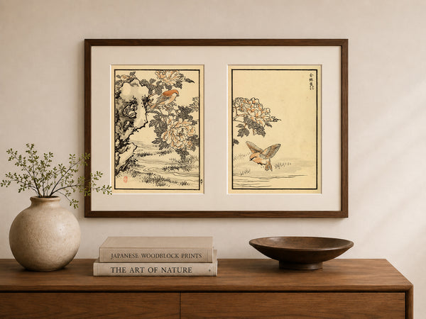 A framed pair of Japanese woodblock prints hanging on a beige wall above a wooden console table. The left print shows a bird perched on a flowering branch, and the right print shows a flying bird.