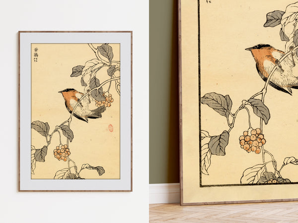 A framed art print featuring a Japanese-style bird perched on a branch with leaves and berries, shown hanging on a white wall alongside a larger view of the same print.